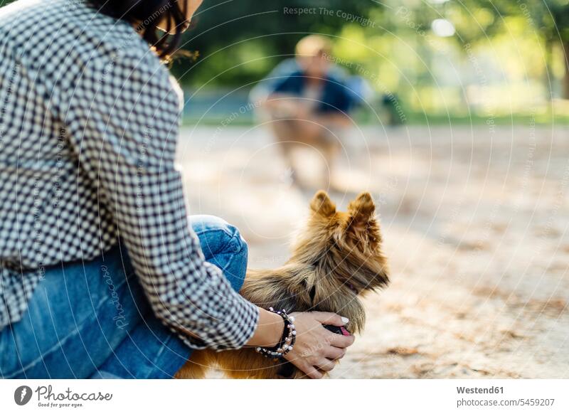 Junge Frau mit Hund in einem Park gegenüber einem Mann Tiere Tierwelt Haustiere Hunde entspannen relaxen Muße Miteinander Zusammen Lifestyles auf Achse