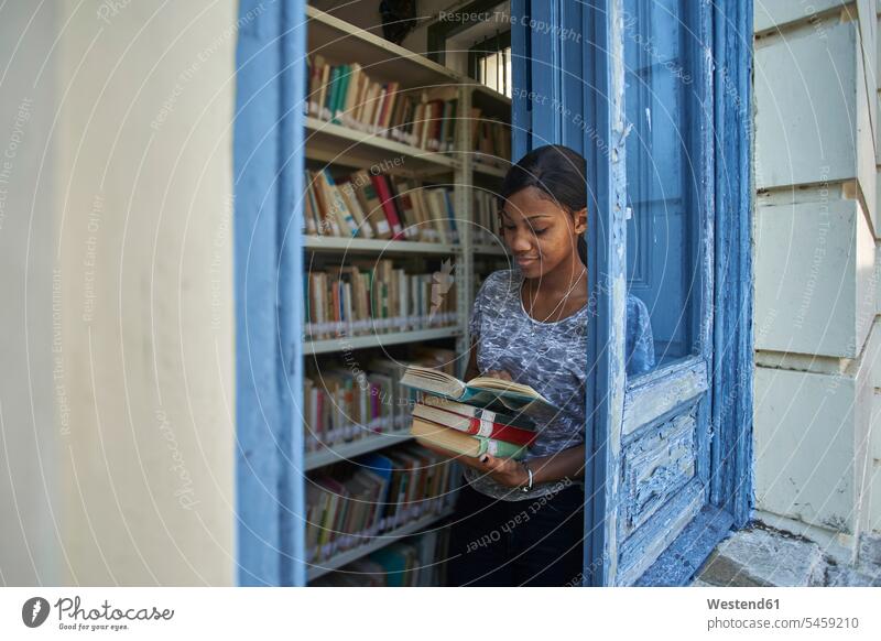Junge Frau beim Ausleihen von Büchern in der Nationalbibliothek, Maputo, Mosambik Ablage Regale Bücherregale Lektüre freuen zufrieden stehend steht Anordnungen