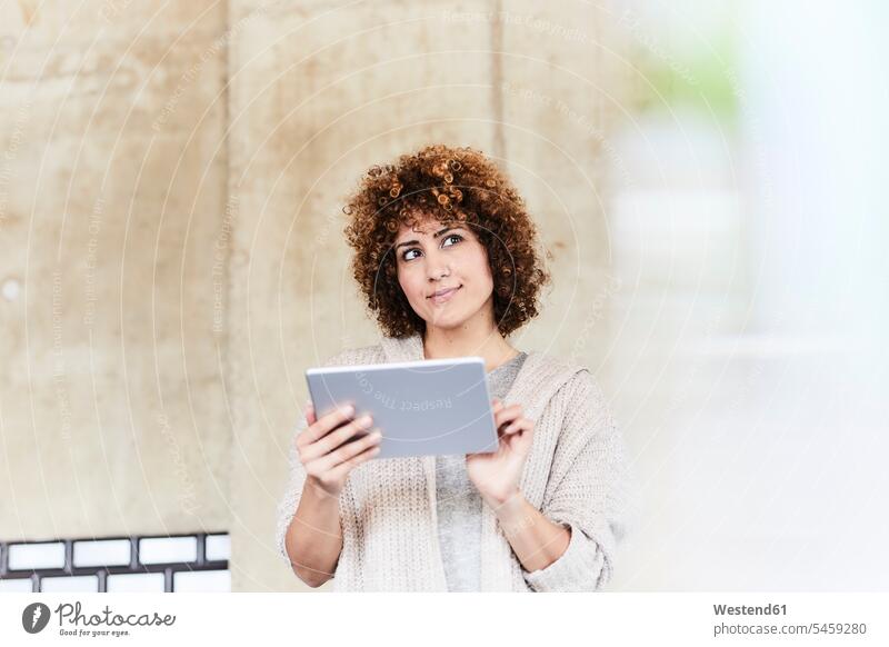 Lächelnde Frau mit Tablet an Betonwand Tablet Computer Tablet-PC Tablet PC iPad Tablet-Computer weiblich Frauen Betonwände Betonwaende lächeln Rechner