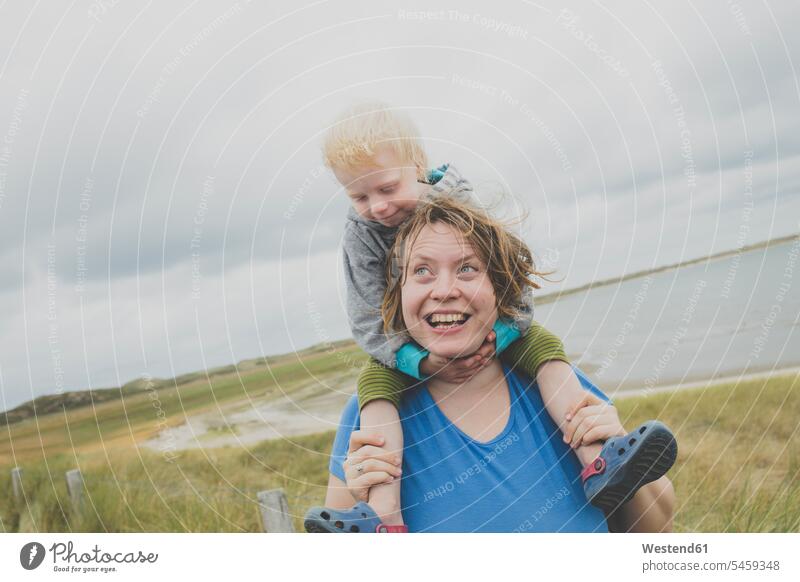 Porträt einer glücklichen Mutter, die ihre kleine Tochter auf den Schultern trägt, Sylt, Deutschland Leute Menschen People Person Personen Europäisch Kaukasier