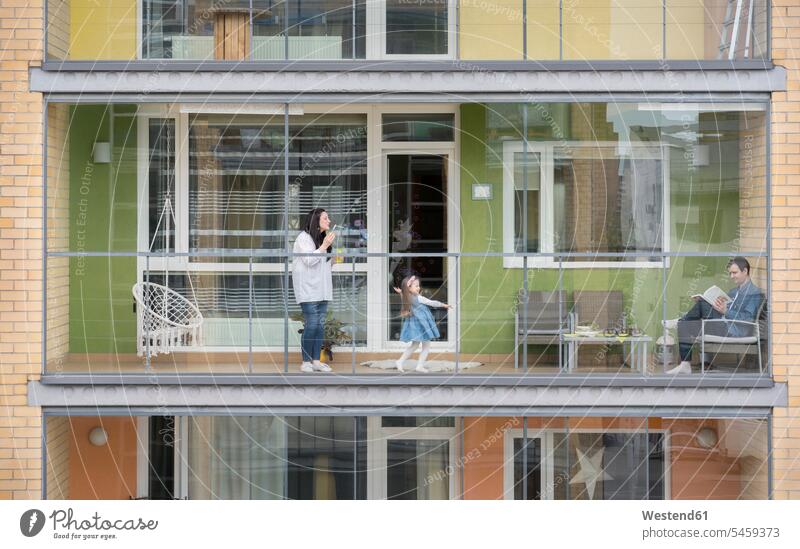 Familie verbringt gemeinsam Zeit auf dem Balkon Seifenblase Muße Lifestyles außen draußen im Freien staedtisch städtisch Urbanität Balkone am Tag Tagesaufnahme
