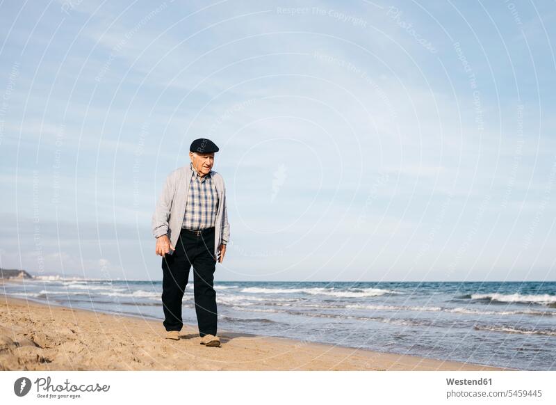 Senior Mann spazieren am Strand im Frühling Entspannung relaxen entspannen Ruhe Beschaulichkeit ruhig Alter Käppi Mütze Kappe Kaeppis Mützen Kappen