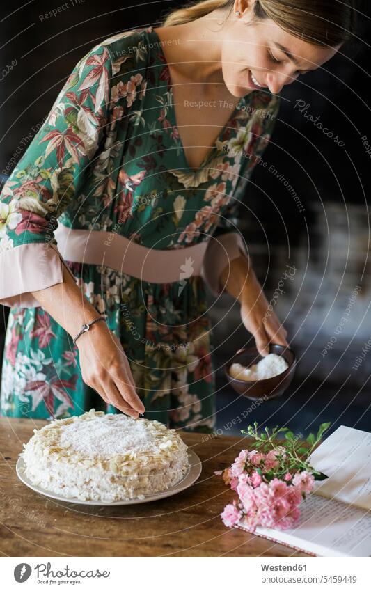 Lächelnde junge Frau garniert selbstgebackenen Kuchen lächeln verzieren weiblich Frauen Erwachsener erwachsen Mensch Menschen Leute People Personen Europäerin