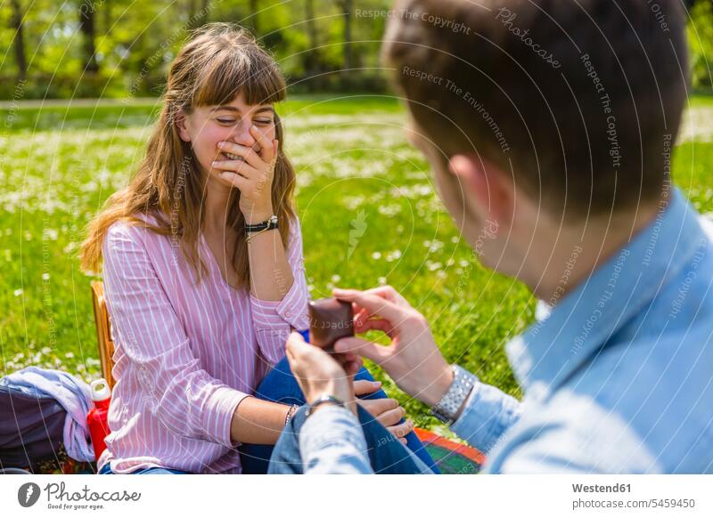 Junger Mann macht seiner Freundin in einem Park einen Heiratsantrag Toskana Schöne Stunden Qualitätszeit Lebensqualität Mußestunden Schöne Momente Quality Time