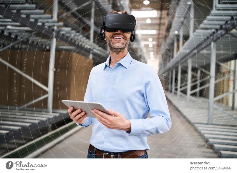Geschäftsmann mit Tablet und VR-Brille in einer Fabrik Job Berufe Berufstätigkeit Beschäftigung Jobs geschäftlich Geschäftsleben Geschäftswelt Geschäftsperson