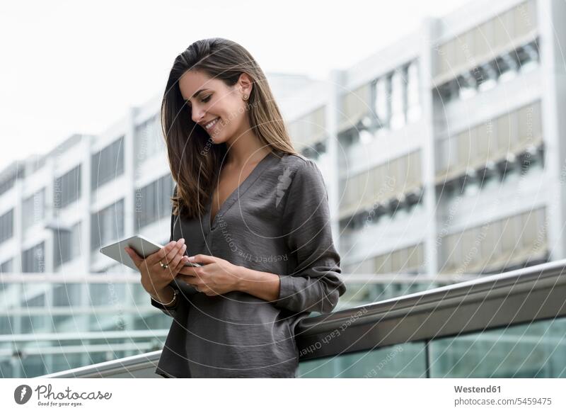Lächelnde junge Geschäftsfrau mit digitalem Tablet im Freien Geschäftsfrauen Businesswomen Businessfrauen Businesswoman Tablet Computer Tablet-PC Tablet PC iPad