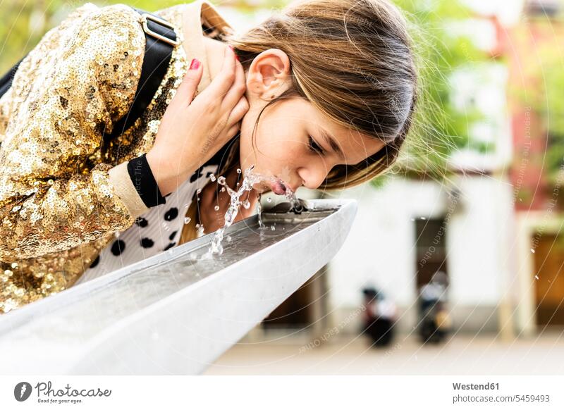 Mädchen trinkt Wasser aus einem Brunnen weiblich trinken Springbrunnen Kind Kinder Kids Mensch Menschen Leute People Personen Paillette Pailletten golden
