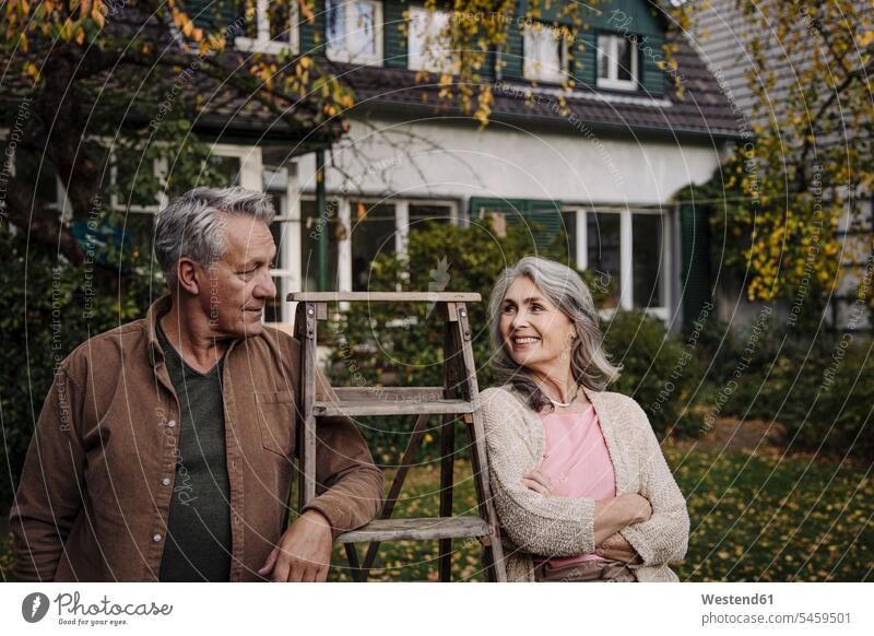 Älteres Ehepaar mit einer Leiter im Garten seines Hauses Leute Menschen People Person Personen Europäisch Kaukasier kaukasisch 2 2 Menschen 2 Personen zwei
