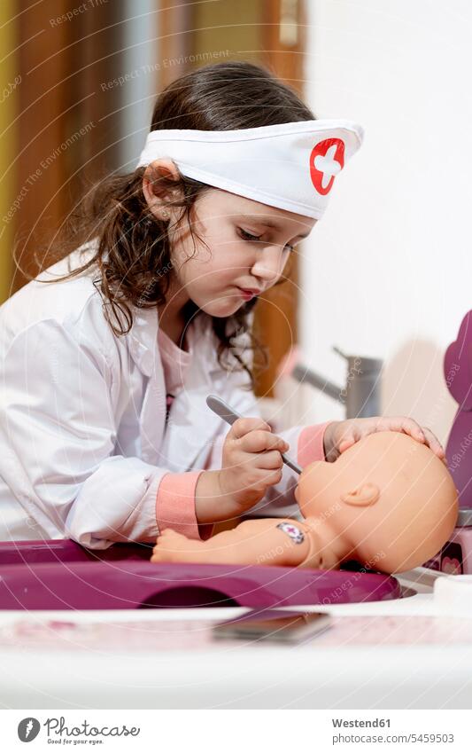 Mädchen in Arztkostüm pflegt ihre Puppe Puppen daheim zu Hause Gesund geschützt schützen Absicherung Raum Räume Bad drinnen Innenaufnahmen schuldlos
