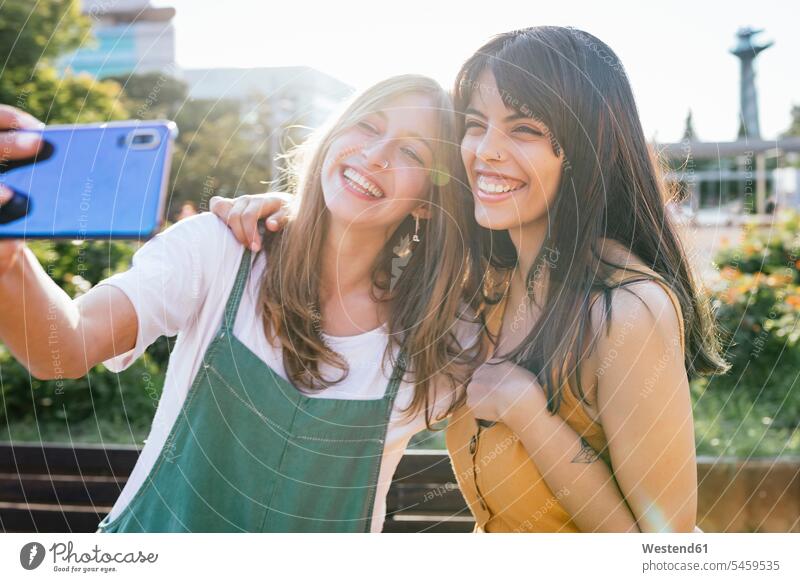 Porträt von zwei glücklichen Freunden, die ein Selfie mit einem Smartphone machen Kameradschaft Freundin Schmuckstueck Schmuckstuecke Schmuckstück Schmuckstücke