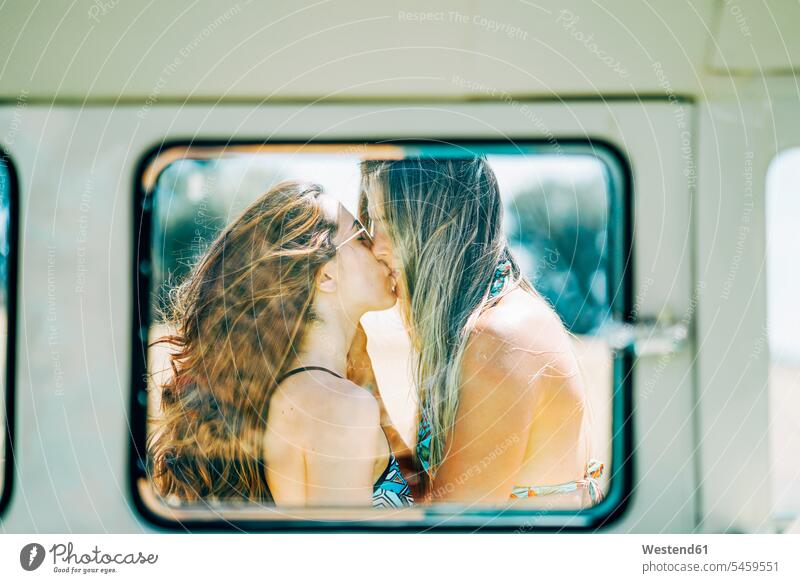 Lesbisches Paar macht einen Road Trip, küssen und umarmen in der Natur Lesbe Lesben Lesbierin Homosexuelle Frauen Lesbierinnen lesbisch Küsse Kuss Autoreise