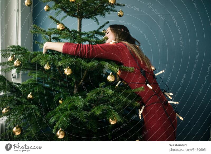 Frau umarmt Weihnachtsbaum umarmen Umarmung Umarmungen Arm umlegen Christbaum Weihnachtsbäume Weihnachtsbaeume Christbäume Christbaeume weiblich Frauen