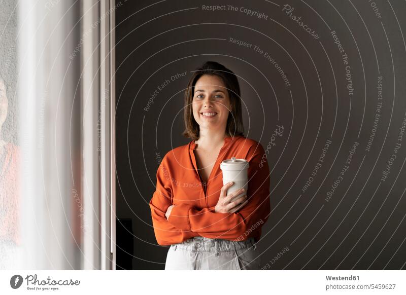 Porträt einer lächelnden Geschäftsfrau mit Kaffeetasse zu Hause Farbaufnahme Farbe Farbfoto Farbphoto Innenaufnahme Innenaufnahmen innen drinnen Tag