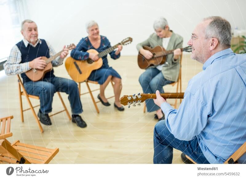 Senioren im Altersheim besuchen Gitarrenkurs, machen Musik Leute Menschen People Person Personen Europäisch Kaukasier kaukasisch Gruppe von Menschen