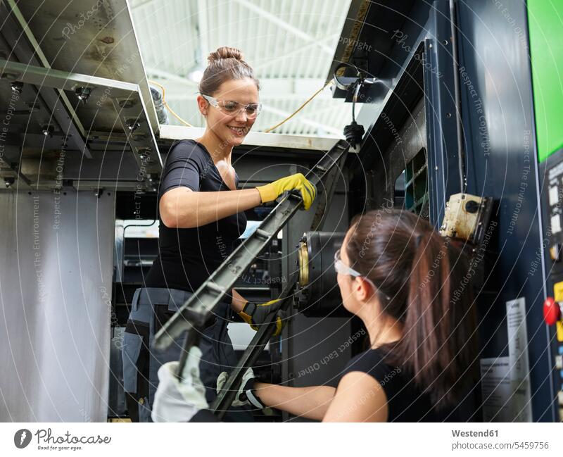 Zwei Frauen arbeiten an einer Maschine. Heben von Stahl Österreich Arbeiterin Arbeiterinnen Metallverarbeitung Kompetenz Fähigkeit Können Metallbau Sachverstand