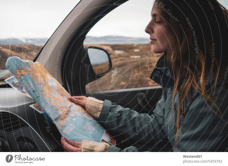 Island, junge Frau im Auto schaut auf Karte Landkarte Landkarten ansehen Wagen PKWs Automobil Autos weiblich Frauen Karten schauen sehend Kraftfahrzeug