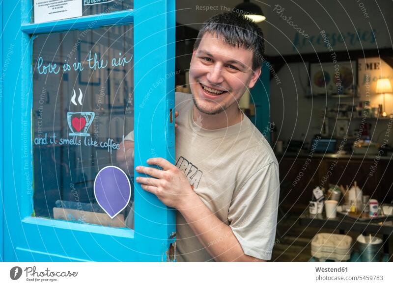 Porträt eines lächelnden Kaffeerösters an der Tür einer Kaffeerösterei Rösterei Geschäft Shop Laden Läden Geschäfte Shops Mann Männer männlich Portrait Porträts