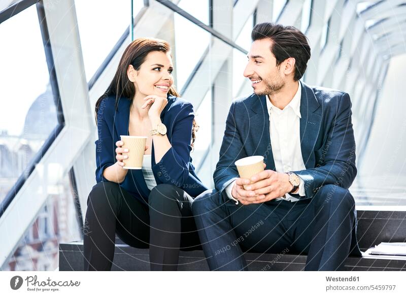 Lächelnde Geschäftsfrau und Geschäftsmann bei einer Kaffeepause im modernen Büro Office Büros Geschäftsfrauen Businesswomen Businessfrauen Businesswoman Pause