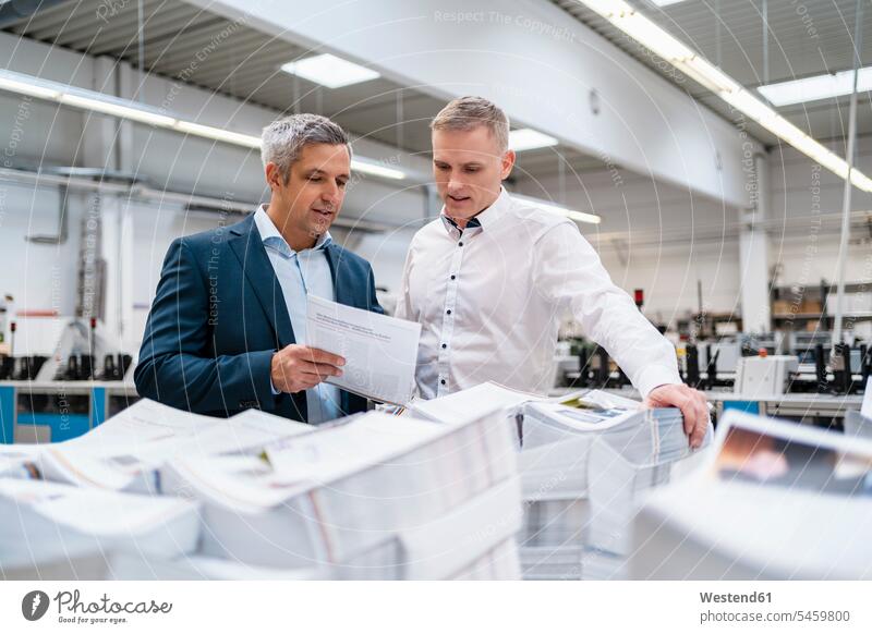 Zwei Geschäftsleute diskutieren in einer Fabrik über Papier geschäftlich Geschäftsleben Geschäftswelt Geschäftsperson Geschäftspersonen Geschäftsfreund