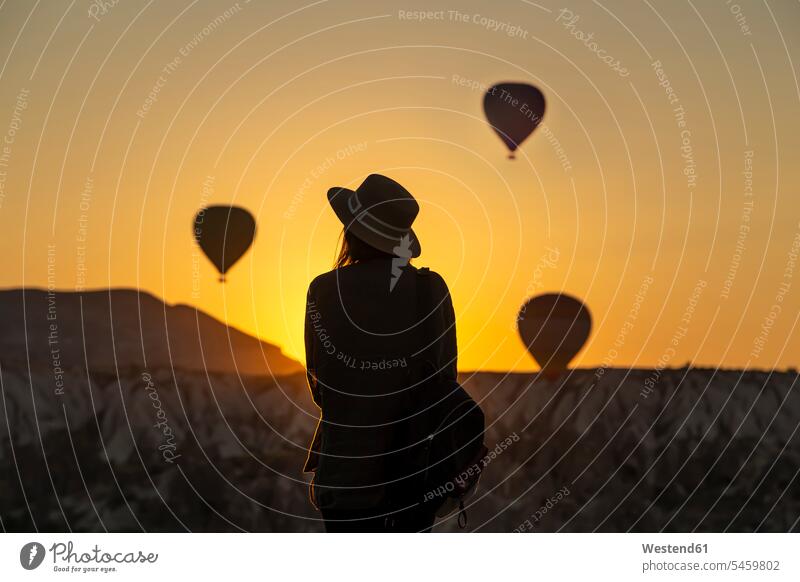 Rückansicht von Silhouette junge Frau Blick auf Heißluftballons, während auf dem Land in Goreme, Kappadokien, Türkei stehen Abenteuer abenteuerlich