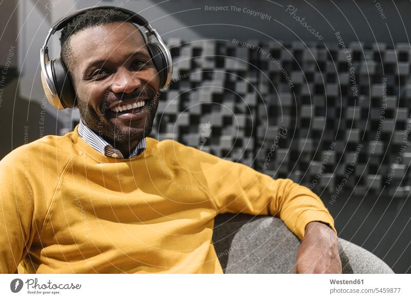 Porträt eines glücklichen Mannes mit Kopfhörern Leute Menschen People Person Personen Afrikanisch Afrikanische Abstammung dunkelhäutig Farbige Farbiger Schwarze