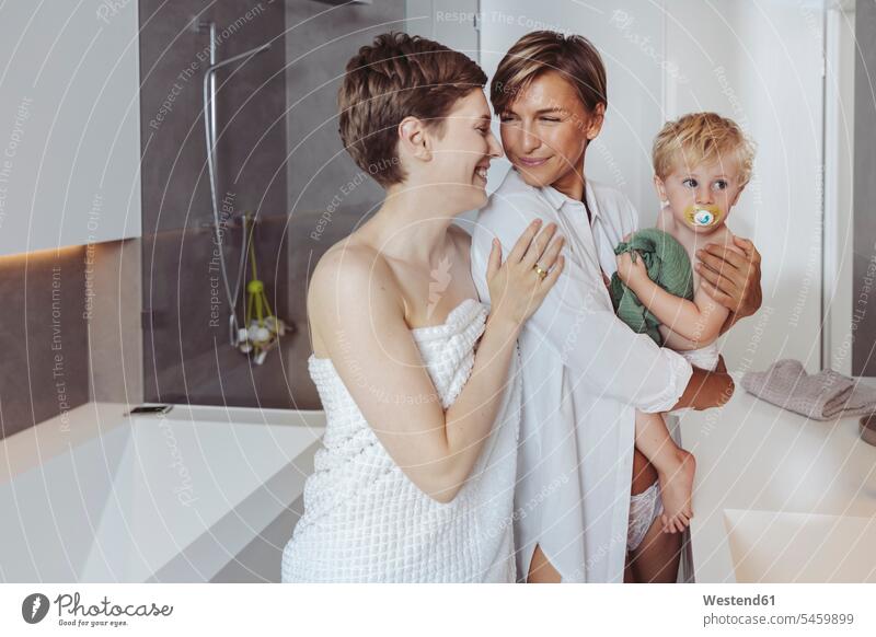 Glückliches lesbisches Paar und ihr kleiner Sohn im Badezimmer glücklich glücklich sein glücklichsein Pärchen Paare Partnerschaft Söhne Mensch Menschen Leute