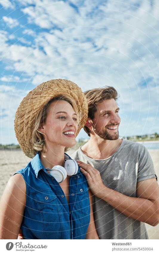 Glückliches junges Paar am Strand Pärchen Paare Partnerschaft Beach Straende Strände Beaches glücklich glücklich sein glücklichsein Mensch Menschen Leute People
