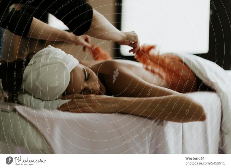 Junge Frau erhält in einem Spa eine Massage mit Federn Massagen massieren weiblich Frauen erhalten bekommen Behandlung Krankenbehandlung Krankenbehandlungen