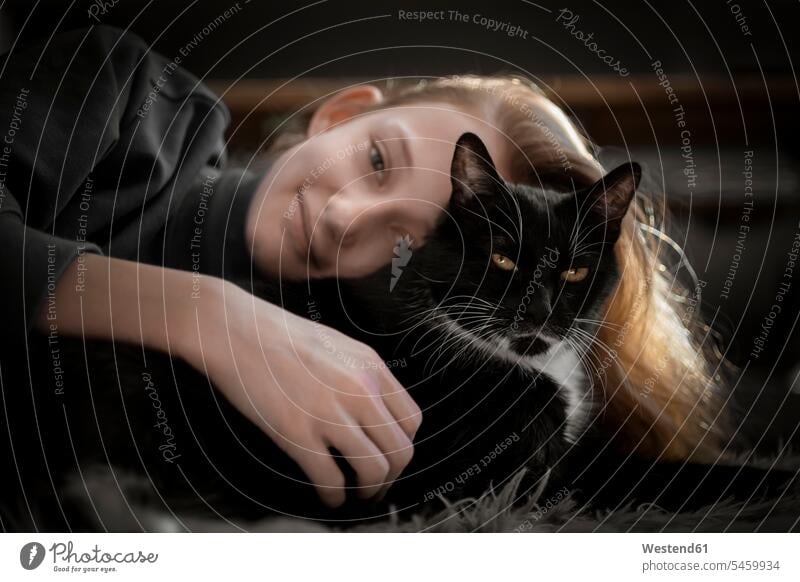 Mädchen kuschelt mit schwarzer Katze Tiere Tierwelt Haustiere Katzen Felis Silvestris Catus Hauskatzen Portraits Porträt Porträts Leute Menschen People Person