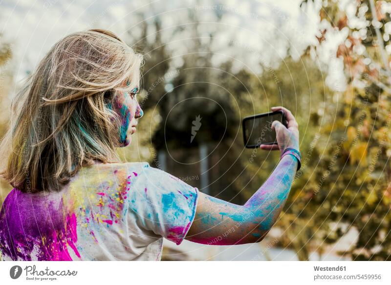 Gir Holi Pulver Farben im Gesicht, Selfie machen, Deutschland Handy Mobiltelefon Handies Handys Mobiltelefone sich von der Masse abheben sich absetzen