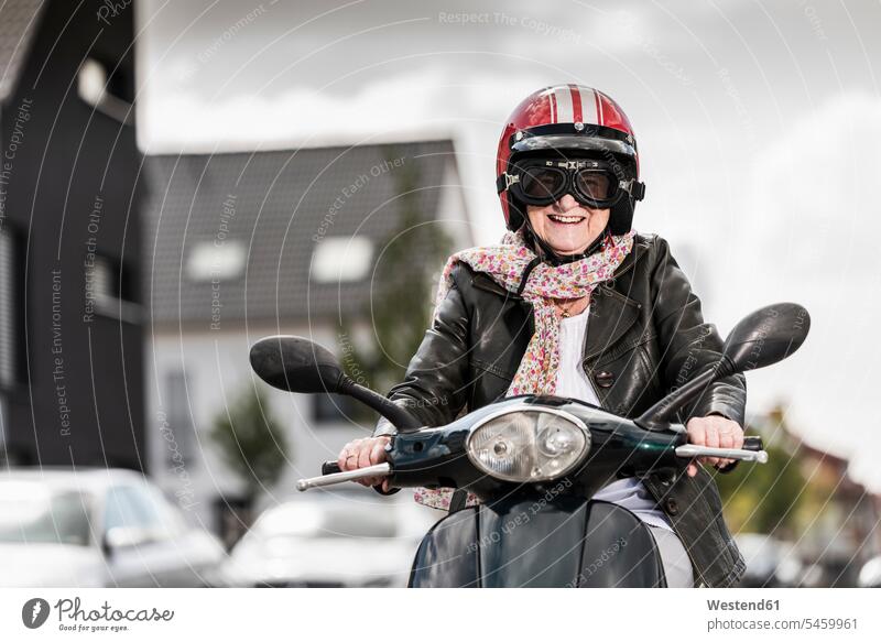 Aktive ältere Dame fährt Motorroller in der Stadt fahren Roller Piaggio Aktive Senioren Seniorinnen Aktiv im Alter Rüstige Rentner Kraftfahrzeug Verkehrsmittel