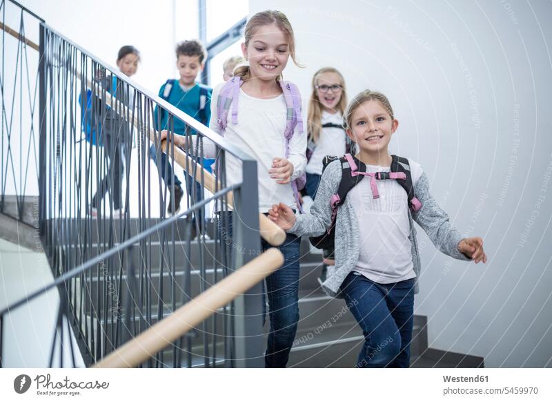 Glückliche Schüler auf der Treppe beim Verlassen der Schule glücklich glücklich sein glücklichsein Schulen verlassen Treppenhaus Treppenhäuser Treppenhaeuser