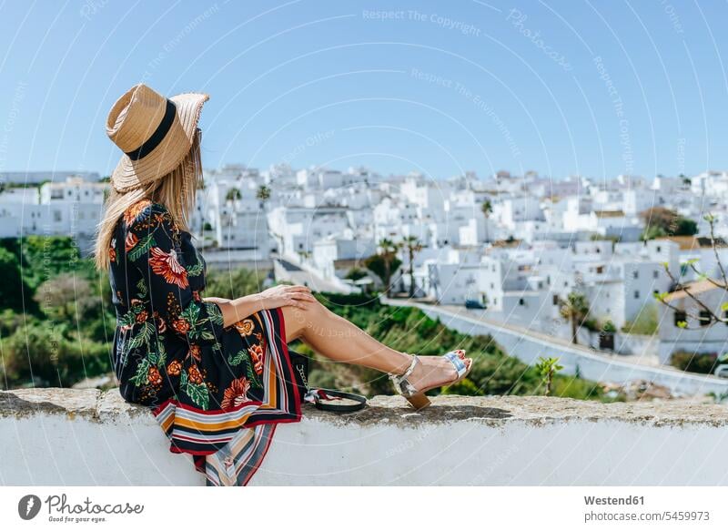 Spanien, Cadiz, Vejer de la Frontera, modische Frau sitzt auf Balustrade und schaut auf die Aussicht Brüstung Ausblick Ansicht Überblick schauen sehend sitzen
