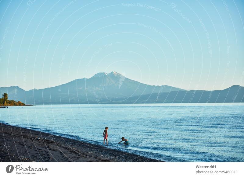 Chile, Lago Llanquihue, Vulkan Calbuco, zwei Jungen spielen im Wasser See Seen Buben Knabe Knaben männlich Gewässer Kind Kinder Kids Mensch Menschen Leute