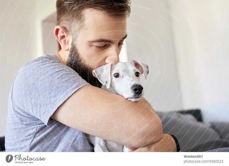 Mann knuddelt seinen Hund zu Hause Hunde knuddeln umarmen Zuhause daheim Männer männlich Haustier Haustiere Tier Tierwelt Tiere Erwachsener erwachsen Mensch
