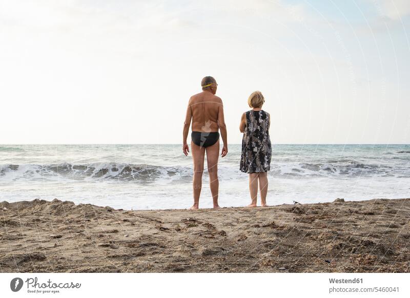Italien, Sizilien, Senior Paar am Strand mit Blick auf das Meer Pärchen Paare Partnerschaft Urlaub Ferien Wasser Rückansicht Rueckansicht Rückenansicht