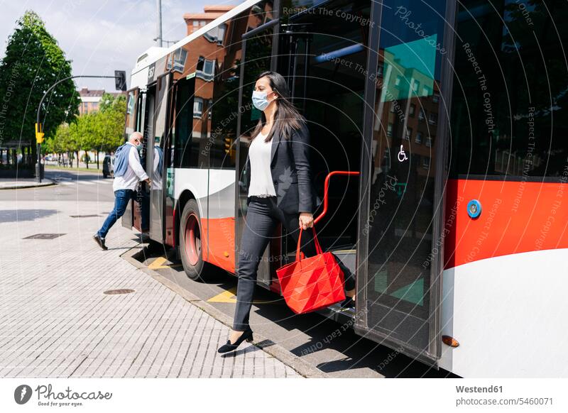 Frau mit Schutzmaske steigt aus öffentlichem Bus aus, Spanien Leute Menschen People Person Personen Europäisch Kaukasier kaukasisch 2 2 Menschen 2 Personen zwei