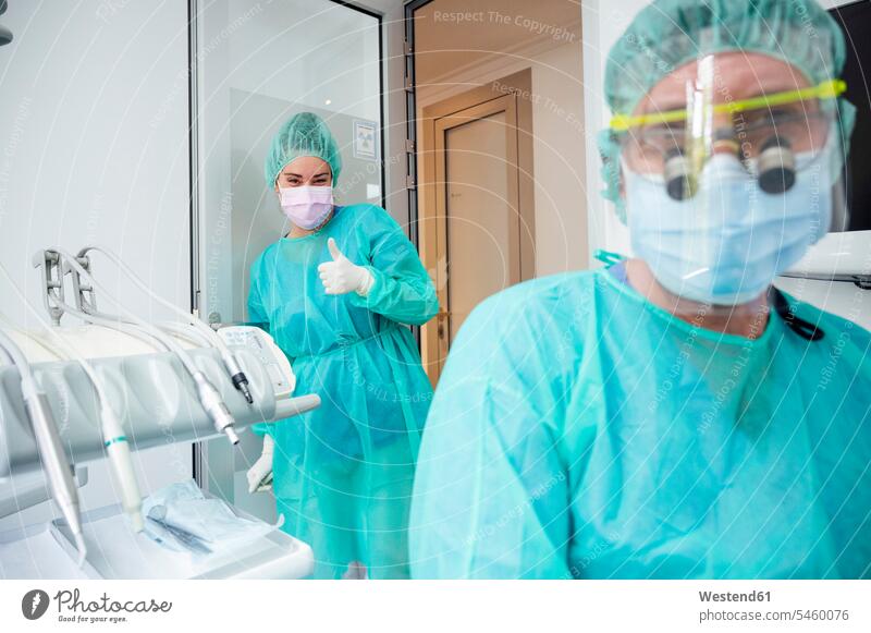 Zahnarzt mit Krankenschwester in Kitteln bei der Arbeit im Krankenhaus Farbaufnahme Farbe Farbfoto Farbphoto Innenaufnahme Innenaufnahmen innen drinnen Medizin