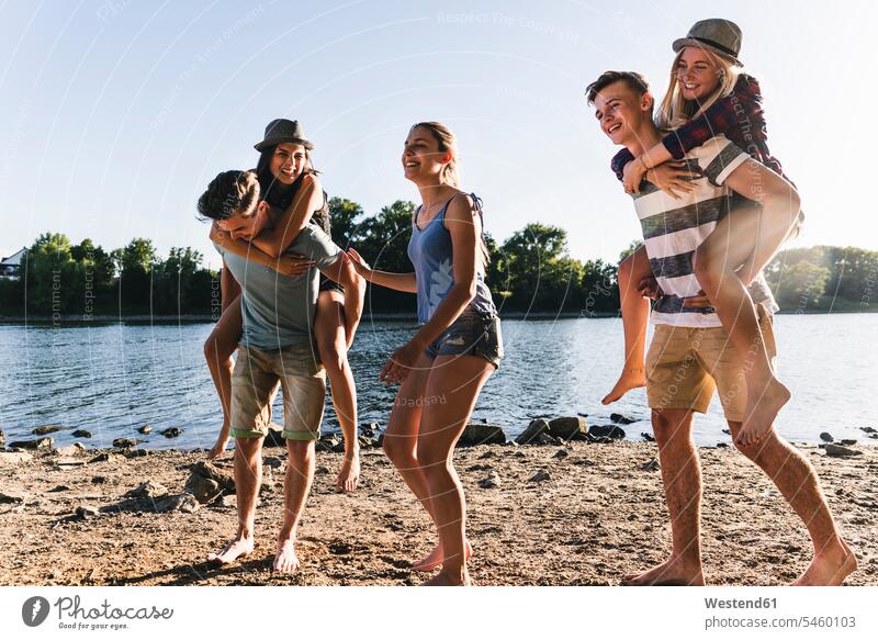 Gruppe glücklicher Freunde am Flussufer Spaß Spass Späße spassig Spässe spaßig Gruppe von Menschen Menschengruppe Glück glücklich sein glücklichsein Fluesse