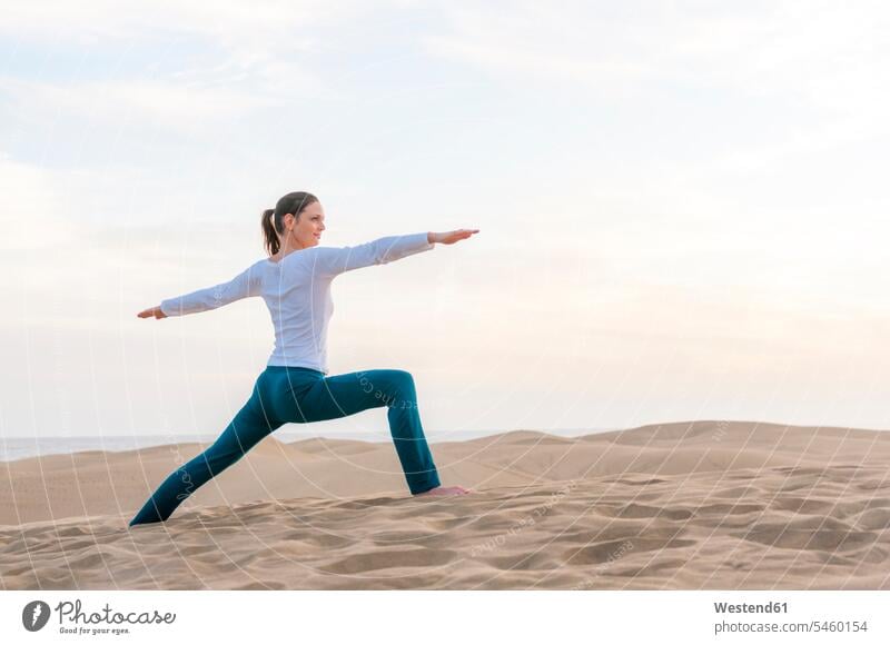 Frau praktiziert Yoga bei Sonnenuntergang in den Dünen, Gran Canaria, Spanien Touristen ausüben trainieren Übung abends entspannen relaxen entspanntheit relaxt