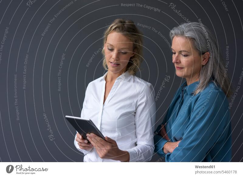 Zwei Geschäftsfrauen schauen gemeinsam auf die Tablette Generation Job Berufe Berufstätigkeit Beschäftigung Jobs geschäftlich Geschäftsleben Geschäftswelt