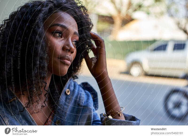 Porträt einer jungen Afrikanerin in einem Cafe, die aus dem Fenster schaut sitzend sitzt Erwartung sehnsüchtig Streben Muße auf Achse in Bewegung Gastronomie