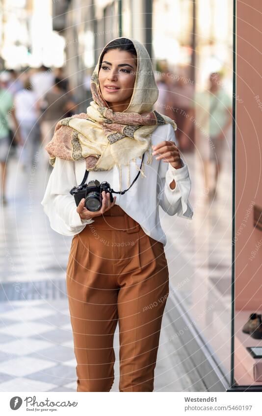 Spanien, Granada, junge arabische Touristin mit Hidschab, beim Einkaufen in der Stadt mit Fotokamera Kopftuch Kopftücher Hijab Frau weiblich Frauen Shopping