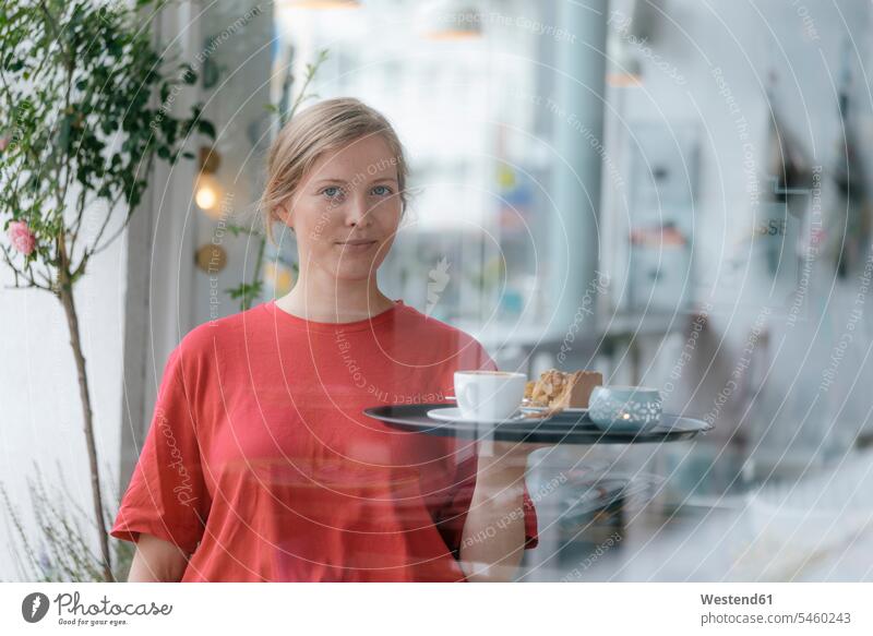 Porträt einer jungen Frau, die Kaffee und Kuchen in einem Café serviert weiblich Frauen Cafe Kaffeehaus Bistro Cafes Cafés Kaffeehäuser servieren Portrait