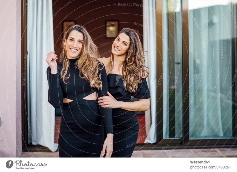 Lächelnde Zwillingsschwestern in Kleidern stehen im Freien am Touristenort Farbaufnahme Farbe Farbfoto Farbphoto Spanien Freizeitbeschäftigung Muße Zeit