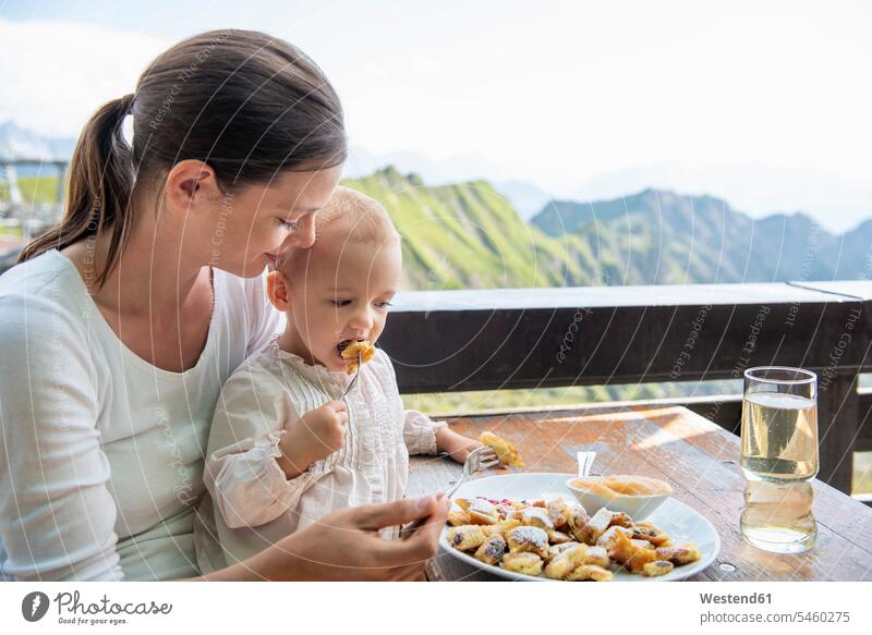 Deutschland, Bayern, Oberstdorf, Mutter und kleine Tochter beim Mittagessen auf einer Berghütte Mamas Mami Mutti Mütter Muetter Mamis Muttis Berghütten