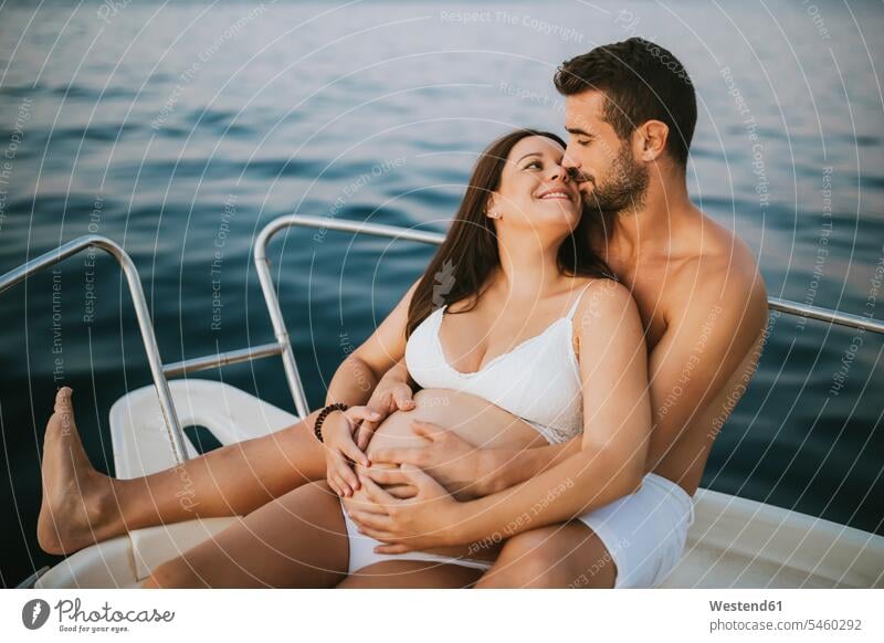 Romantisches Paar mit schwangerer Frau auf Boot sitzend Leute Menschen People Person Personen Europäisch Kaukasier kaukasisch 2 2 Menschen 2 Personen zwei