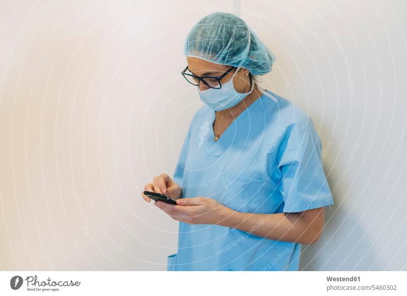 Weiblicher Arzt mit Smartphone im Krankenhaus, Vorbereitung für die Operation Beruf Berufstätigkeit Berufe Beschäftigung Jobs Textfreiraum vorbereiten