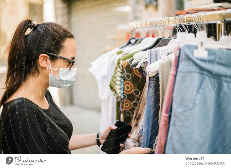 Frau mit Schutzmaske beim Einkaufen Brillen Sonnenbrillen Kauf shoppen shopping Lifestyles Fashion modisch geschützt schützen Absicherung ausgesucht Auslese