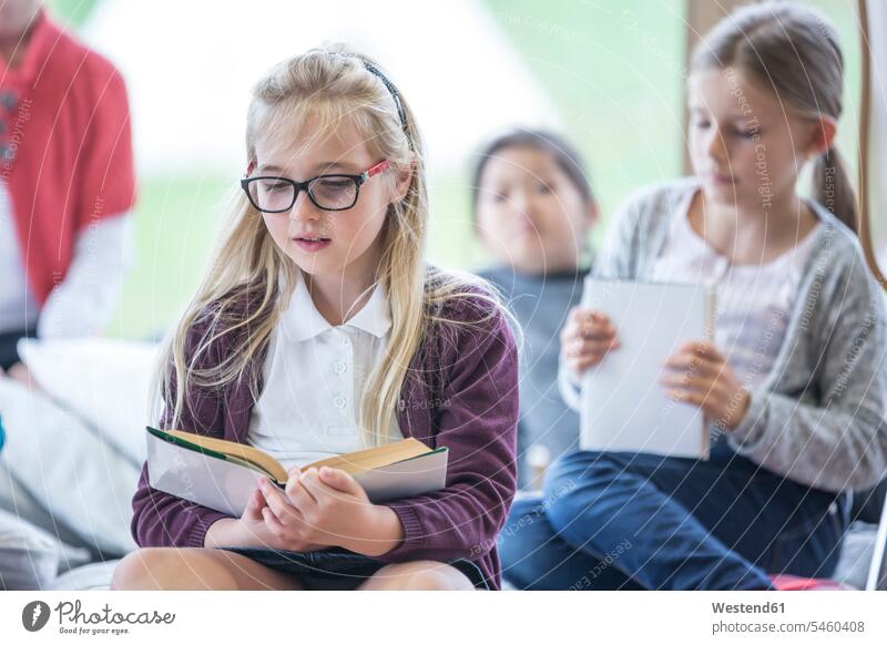 Schulmädchen lesen Bücher im Pausenraum der Schule Buch Schülerin Schulkind Bildung nur Mädchen sitzen Hobby smart brav Gemeinsam Freizeitbeschäftigung Wissen